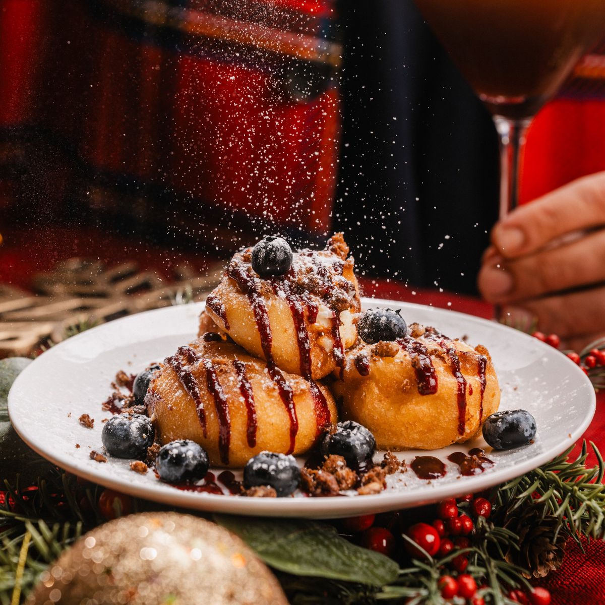 Beignets de cheesecake garnis de coulis, de crumble et de bleuets